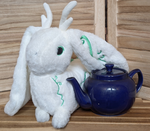 A yetsona sits by a teapot